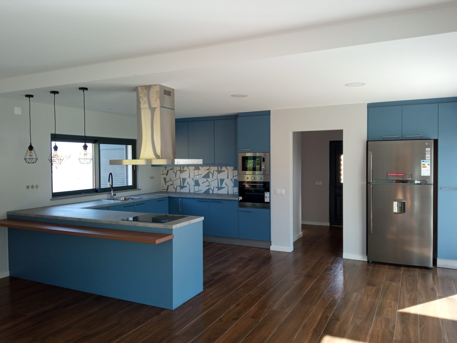 Blue kitchen with island and wood detailing completed by RBWF