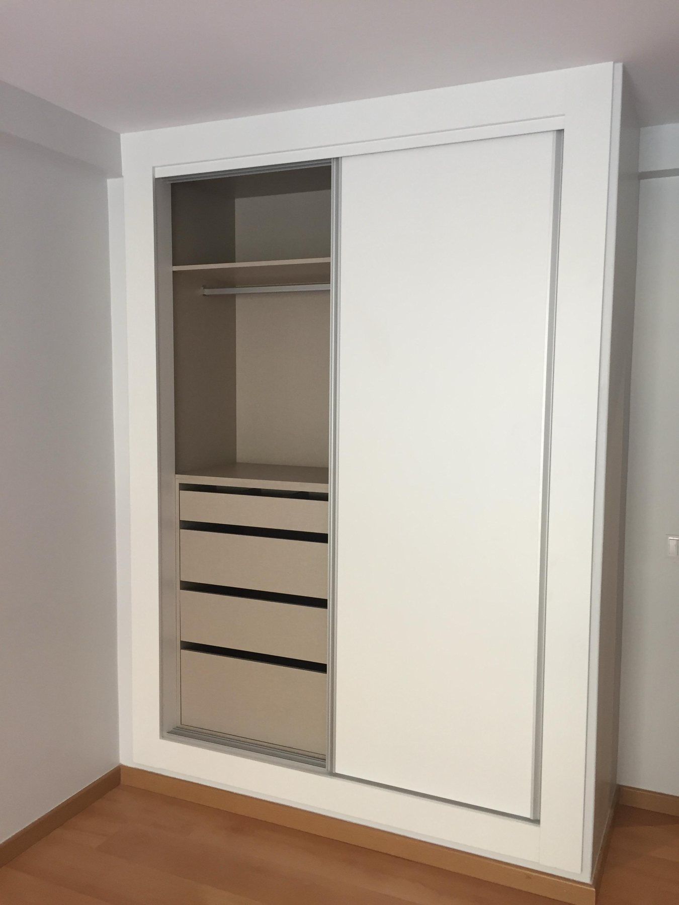 Roupeiro branco com portas deslizantes e interior organizado