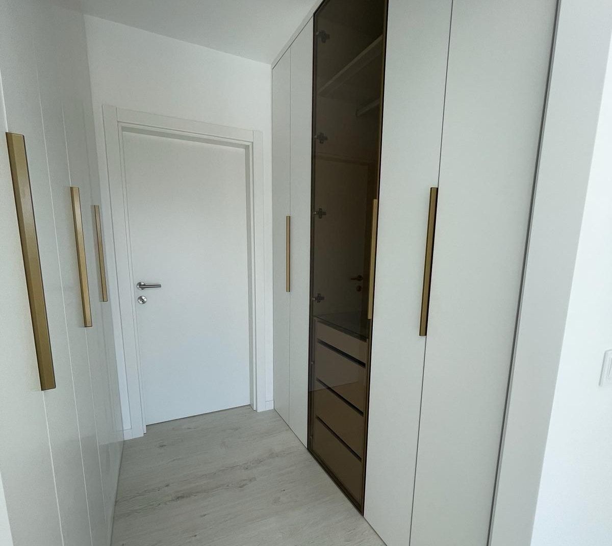 Roupeiro com portas de vidro fumado e organização interior